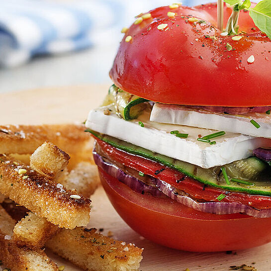 Vegetarischer Tomatenburger mit Gemüse serviert mit knusprigen Brot-Frites